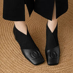 Black square-toe ankle boots with cushioned collar and embossed circular logo detail