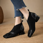 Black square-toe ankle boots with chunky block heel and embossed circular logo detail