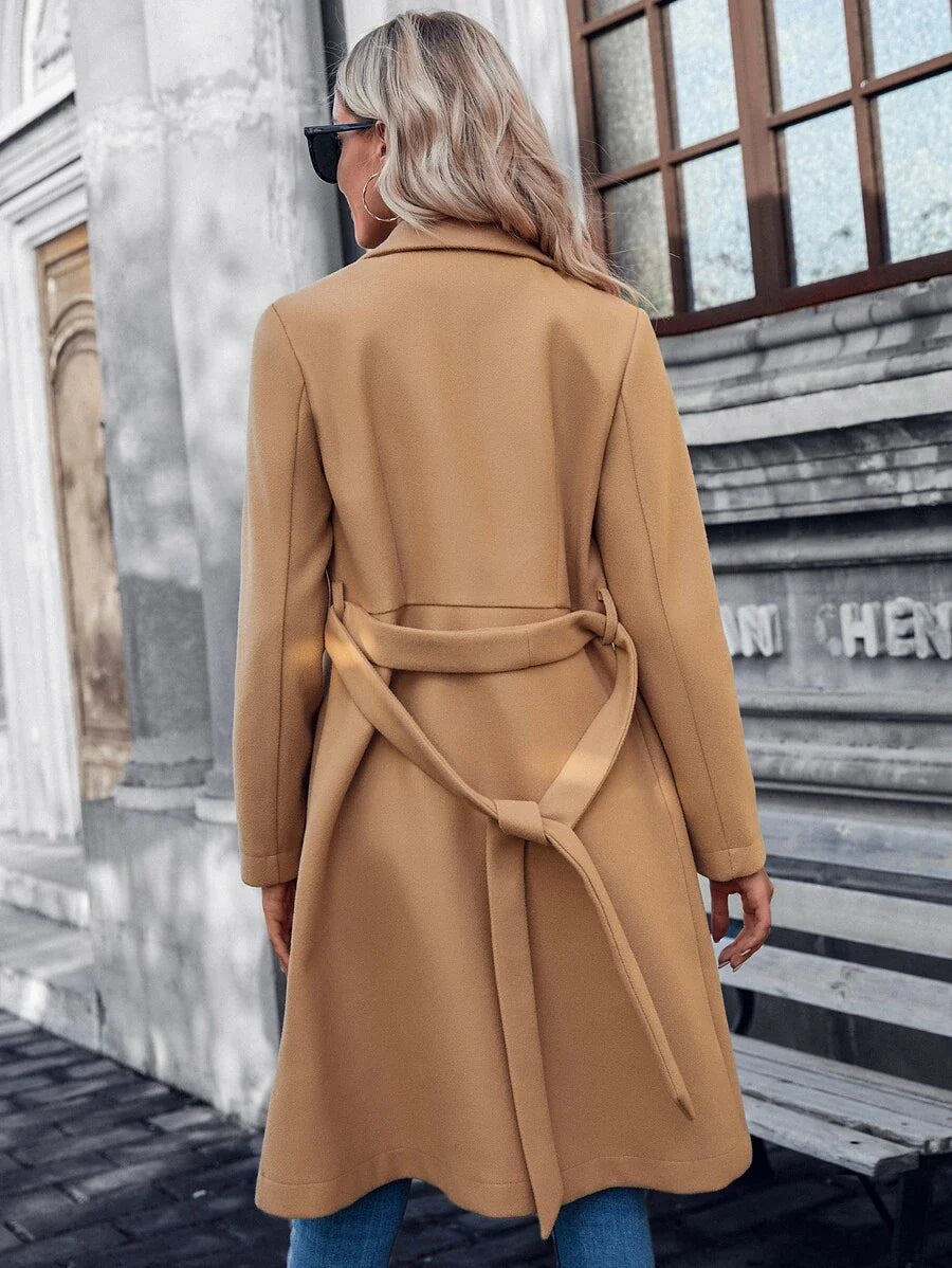 Beige double-breasted A-line coat, back view, tied waist belt and long sleeves