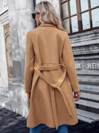 Beige double-breasted A-line coat, back view, tied waist belt and long sleeves