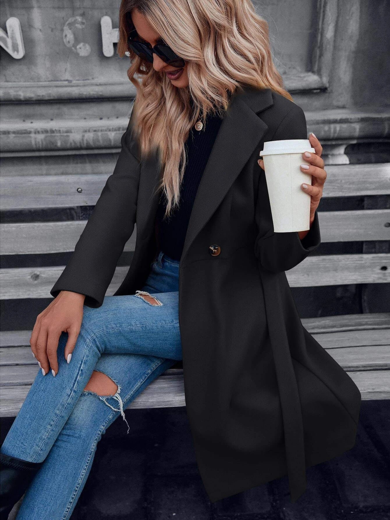 Black double-breasted A-line coat with lapels and tied waist belt, long sleeves