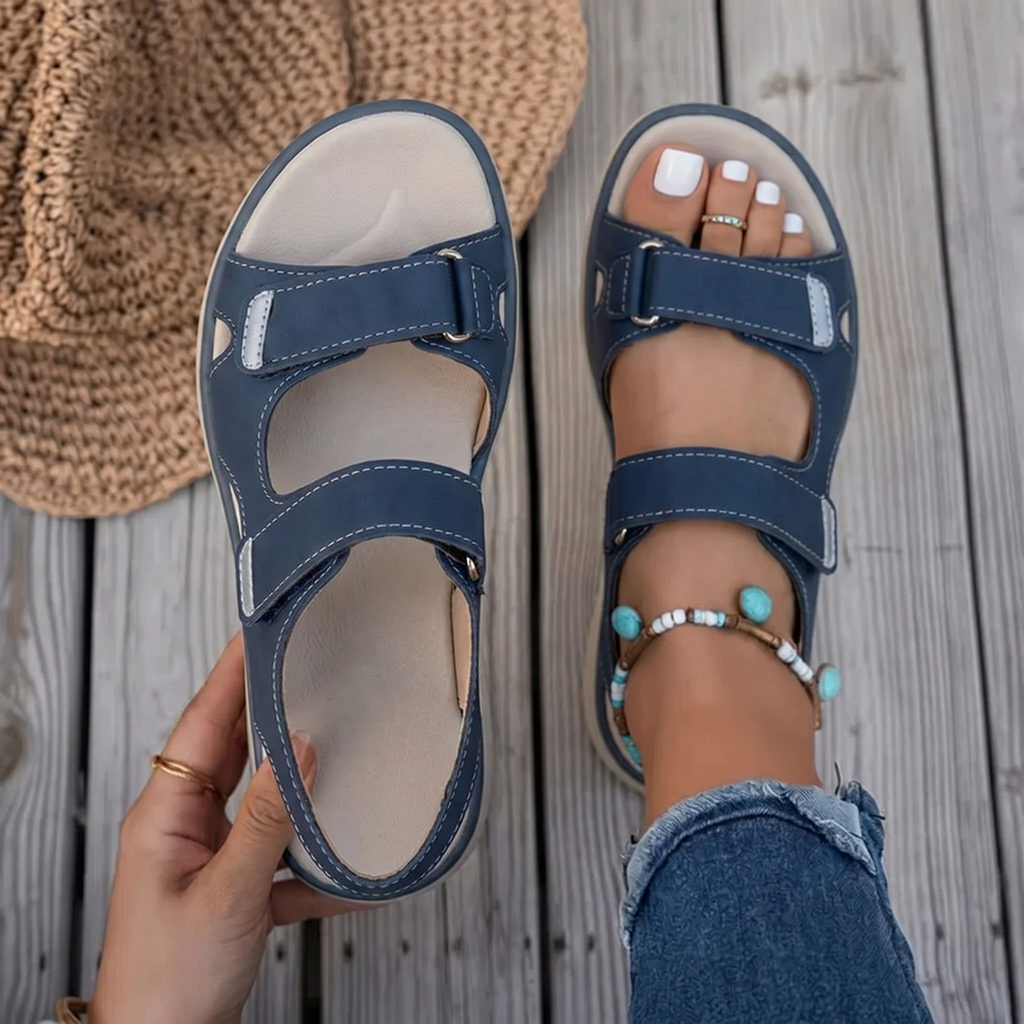 Dark blue cushioned sandals with hook-and-loop straps worn on feet