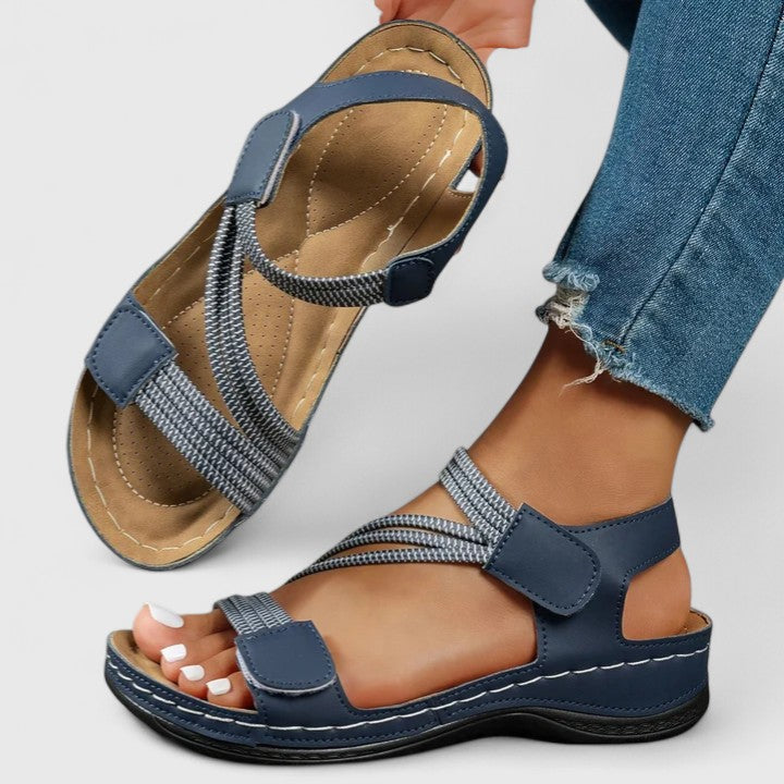 Blue cushioned wedge sandals with knit straps and hook closure, open toe