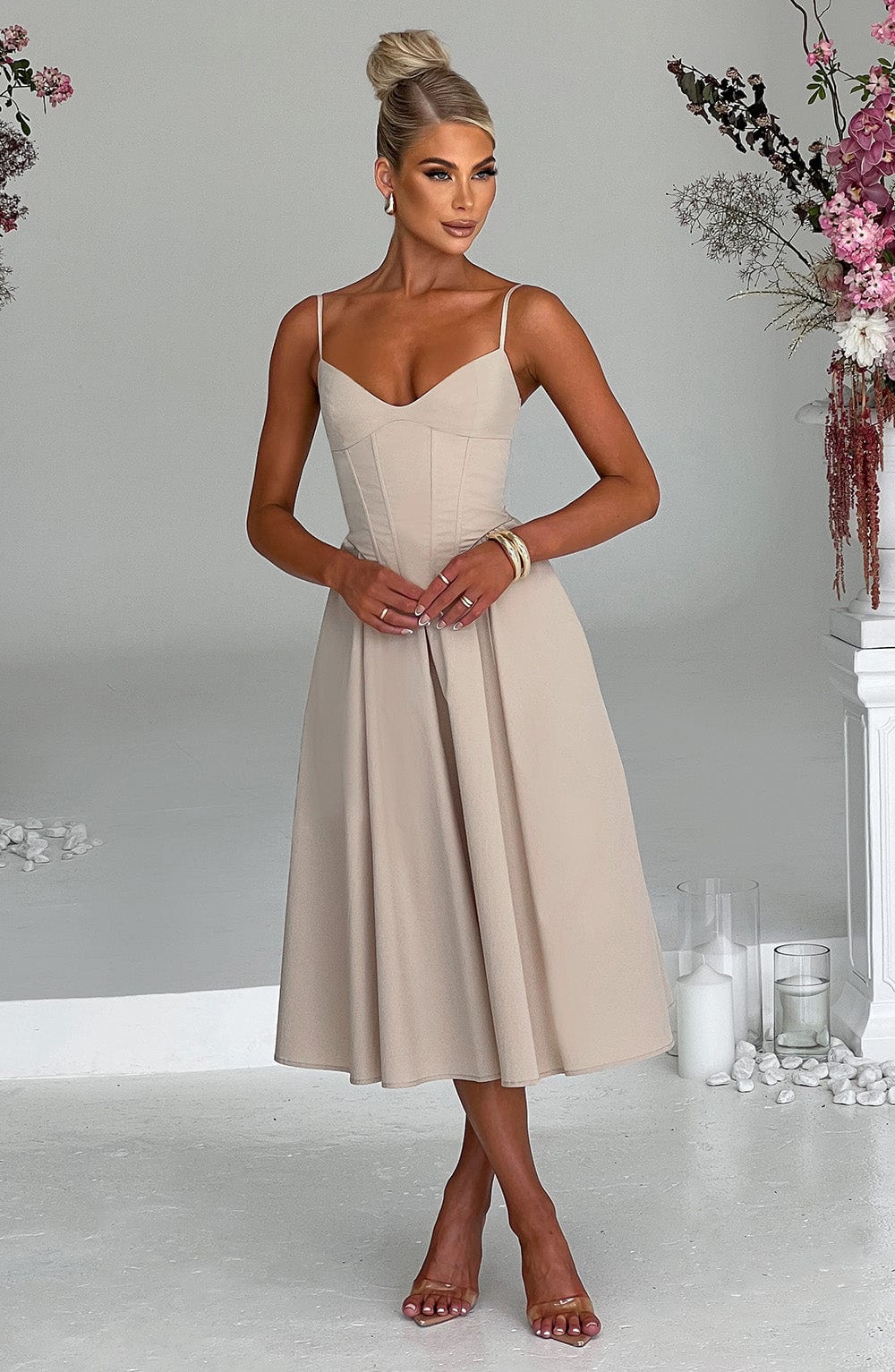 Beige corset midi dress with spaghetti straps and fitted bodice, pleated skirt