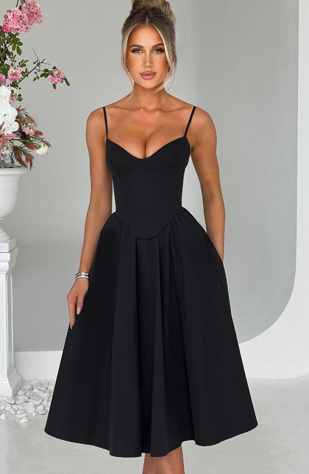 Black corset midi dress with spaghetti straps and corset-style waist, flared pleated skirt