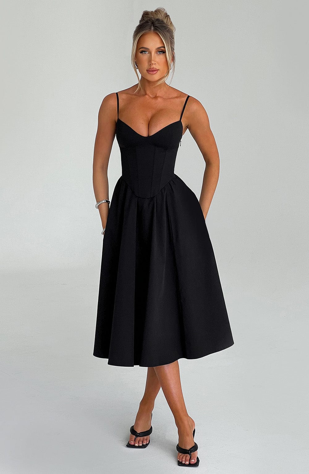 Black corset midi dress with spaghetti straps and contoured waist seam, pleated skirt