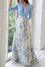 Light blue V-neck maxi dress with long sleeves, gathered waist, and blue floral skirt.