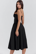 Black A-line midi dress with spaghetti straps and pleated skirt, side view