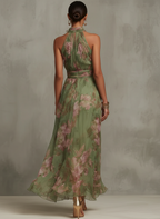 Women’s halter maxi dress, back view, green floral print with gathered waist detail.