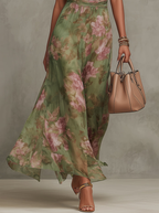 Women’s halter maxi dress skirt detail, green floral print, lightweight flowy fabric.