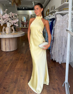 Yellow satin halter neck maxi dress with high neckline and long sleek skirt