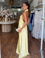 Yellow satin halter neck maxi dress from side view, backless open style and long hem