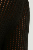 Close-up of black sheer knit fabric with circular cutout texture