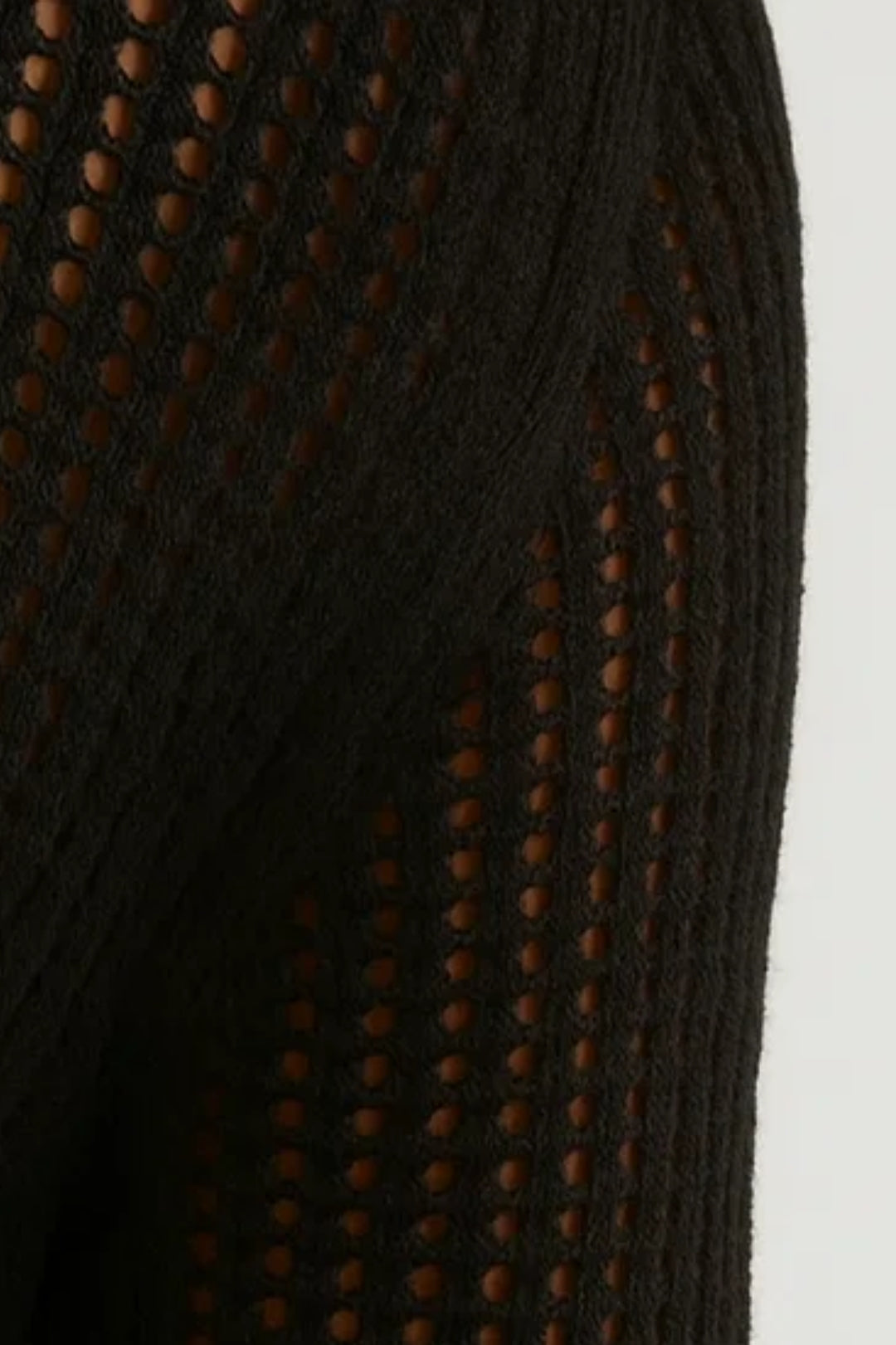 Close-up of black sheer knit fabric with circular cutout texture