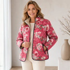 Pink floral quilted lightweight jacket worn by model, snap-front with stand collar