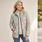 Lightweight quilted floral jacket in teal with pink roses and black trim, worn with jeans
