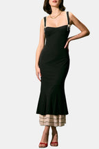 Black fitted midi dress with spaghetti straps and ruffle hem over cream underlayer
