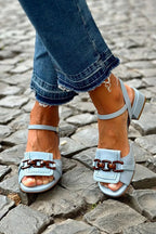 Light blue heeled sandals with adjustable ankle strap and buckle closure