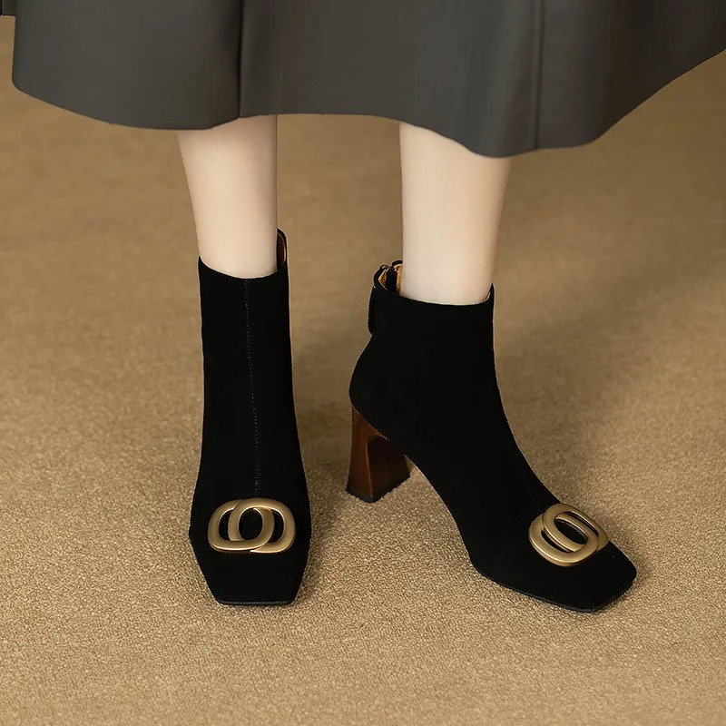 Pair of black velvet ankle boots with gold O-ring buckle and block heel