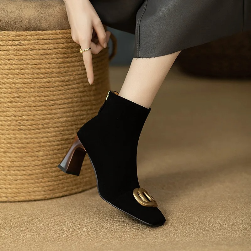 Black velvet ankle boots with block heel and gold O-ring buckle, side view