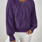 Dark purple cable knit sweater with voluminous sleeves, textured diamond pattern, zip neck