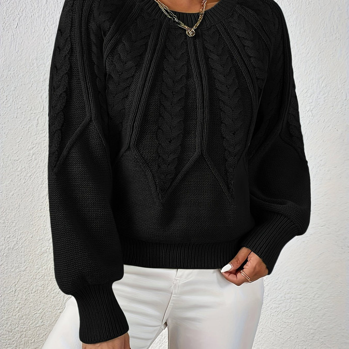 Black cable knit sweater with voluminous sleeves, textured cable diamond pattern, zip neck