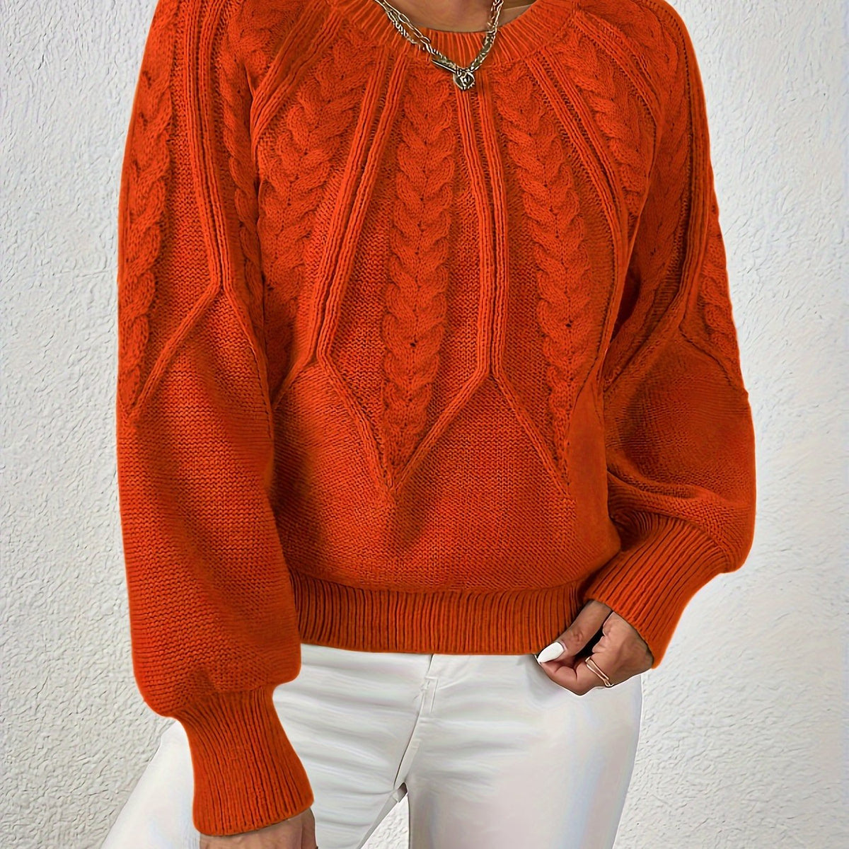 Orange cable knit sweater with voluminous sleeves, textured cable diamond pattern, zip neck