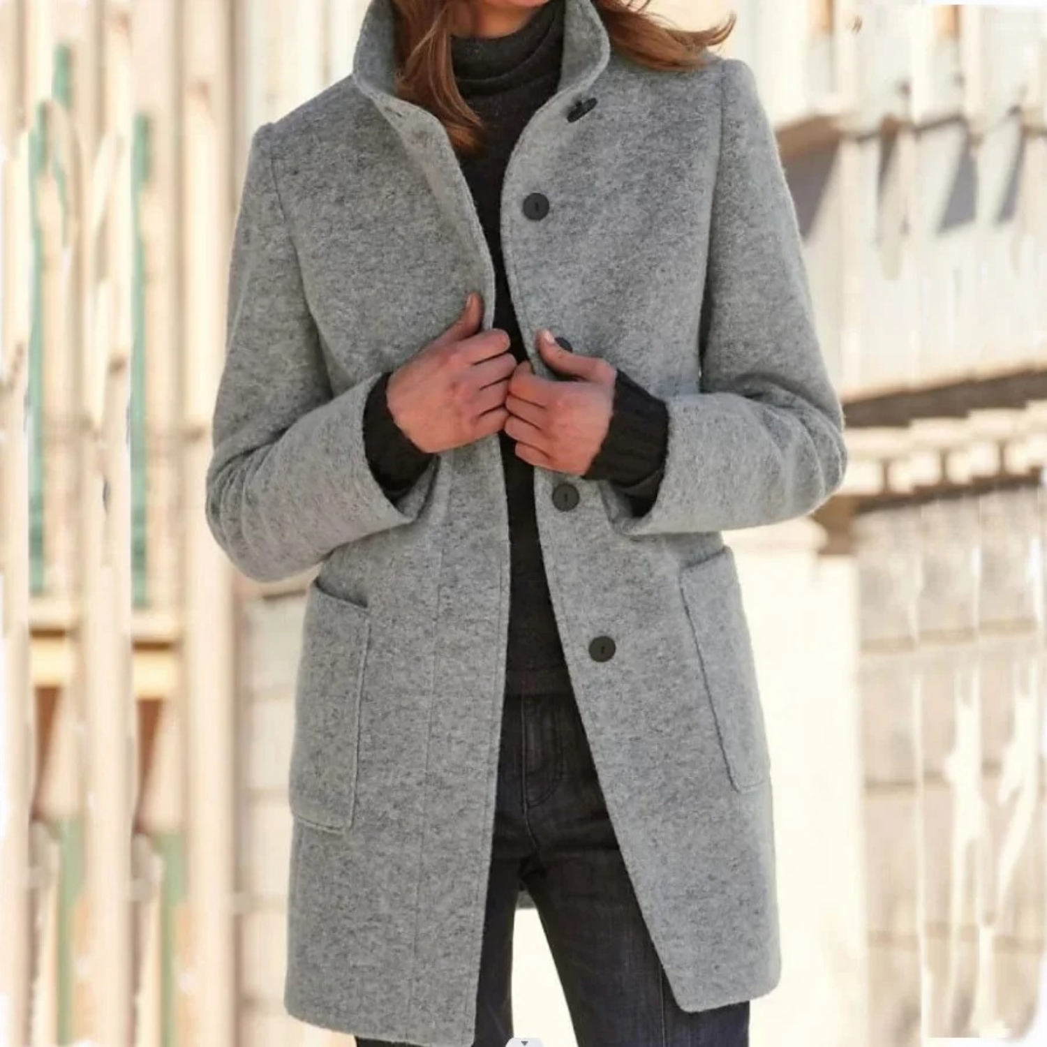 Women’s light gray stand-collar winter coat with button front and side pockets.