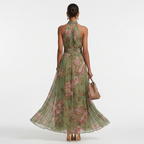 Women’s halter maxi dress, back full view, green floral print and flowing maxi hem.