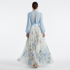 Light blue V-neck maxi dress with open back, long sleeves, and blue floral A-line skirt.