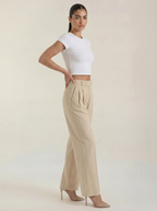 Pleated high-rise wide-leg pants in beige, relaxed fit with pleated front