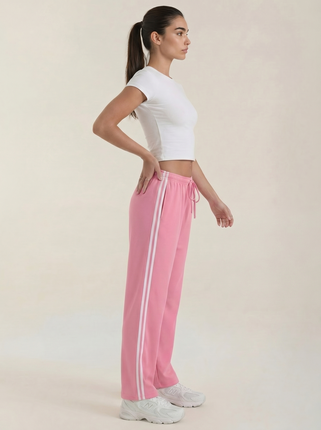 Pink wide-leg track pants, side view, elastic waist and drawstring with stripe