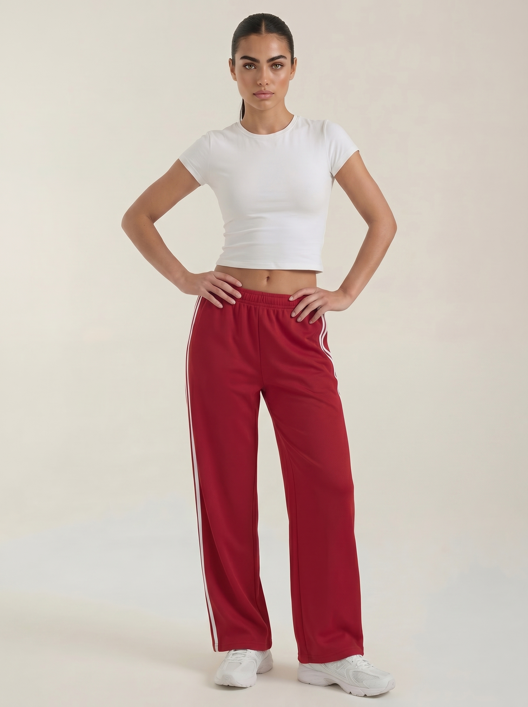 Red wide-leg track pants with elastic waist, drawstring, and white side stripes