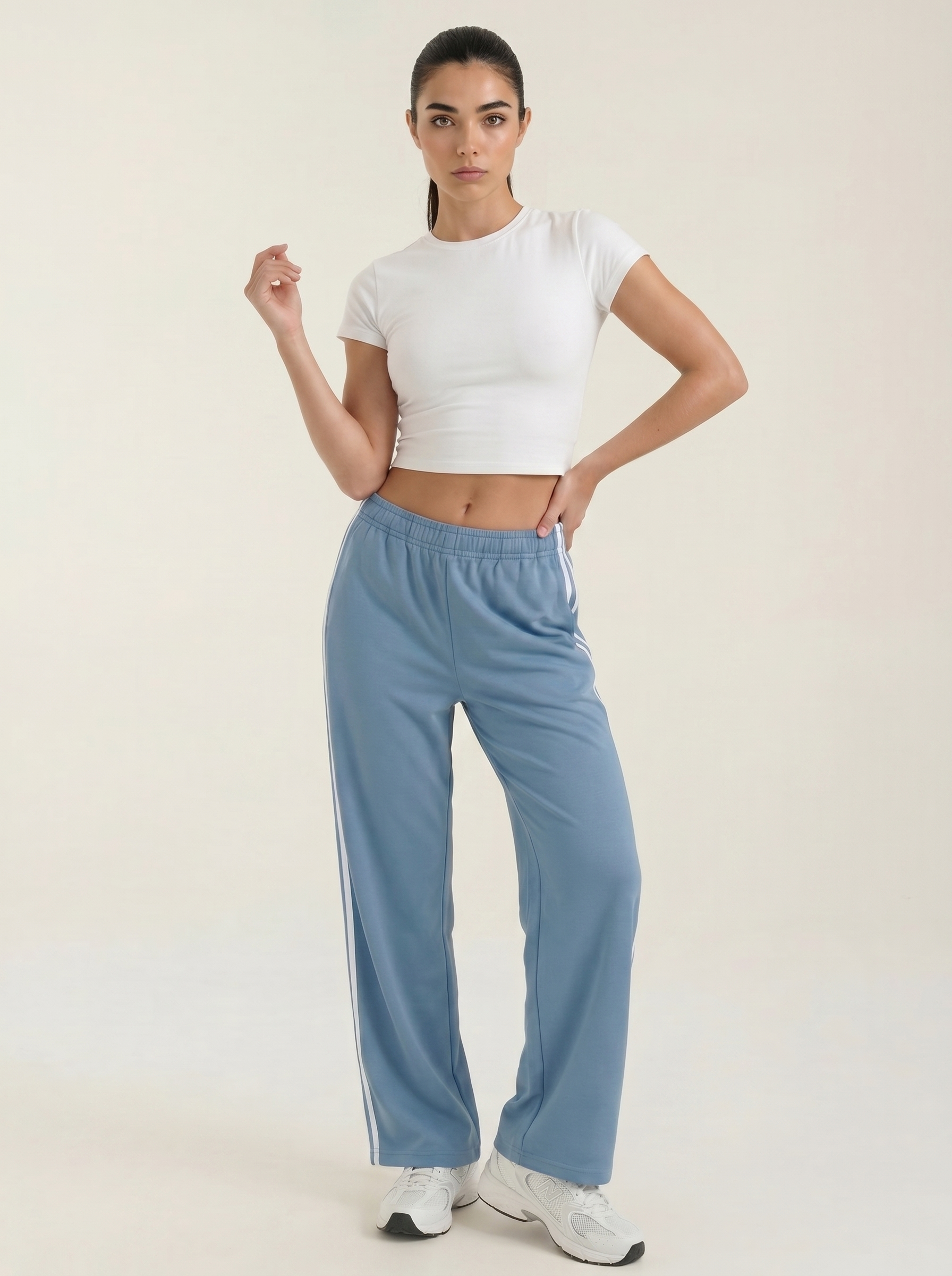 Blue wide-leg track pants with elastic waist, drawstring, and side stripe