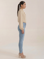 Beige draped long-sleeve blouse viewed from the side, with cowl neckline