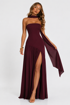 Burgundy strapless maxi dress with pleated skirt and high side slit, flowing draped panel