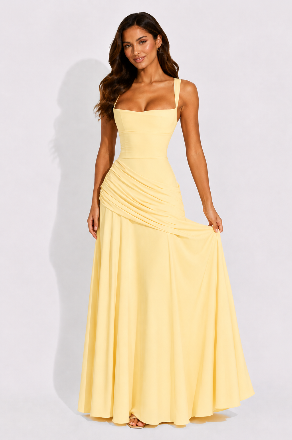 Yellow maxi dress with square neckline and draped waist, sleeveless, flowing skirt.