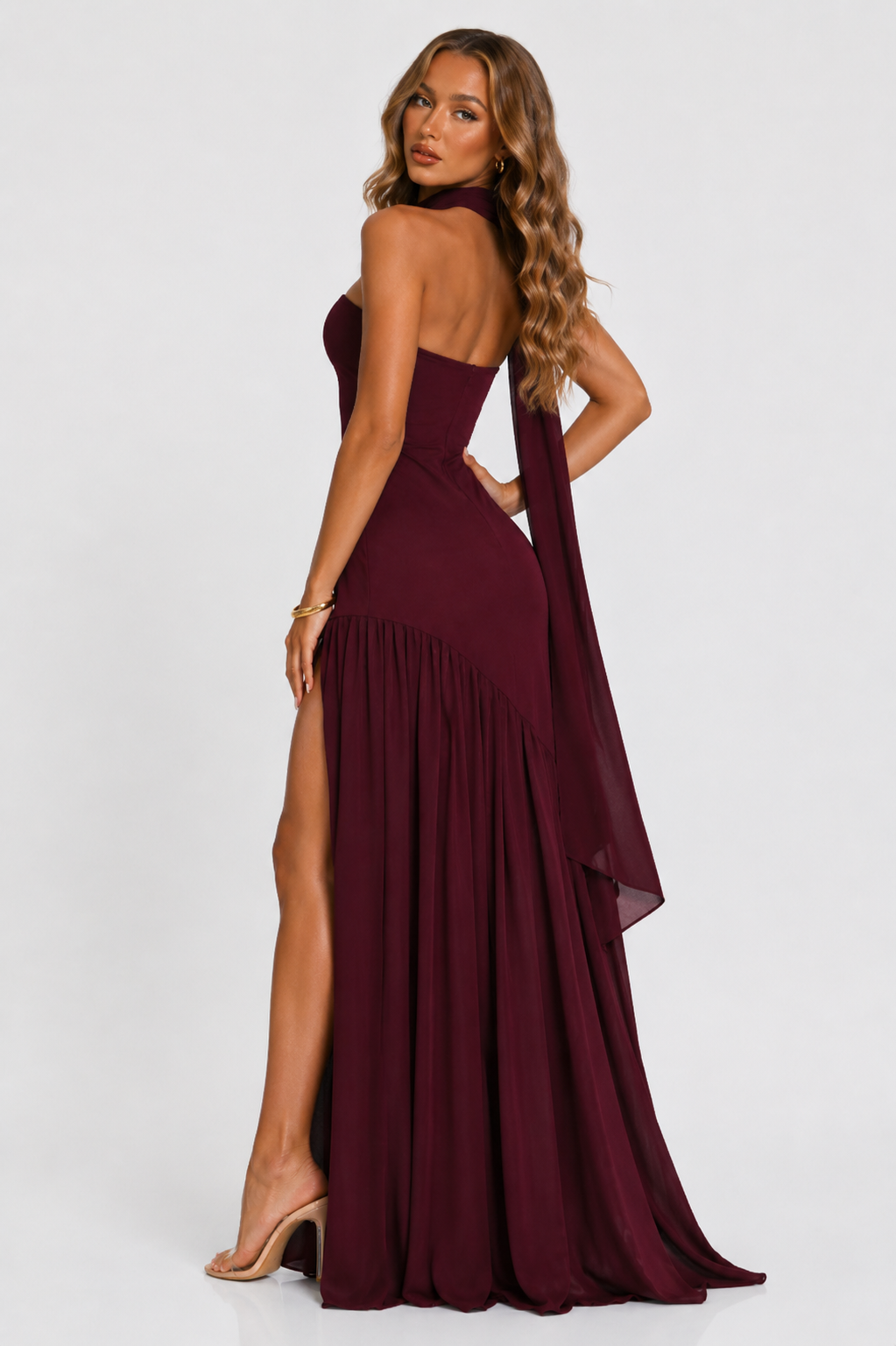 Burgundy strapless maxi dress with pleated skirt and high side slit, back view
