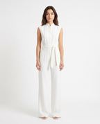 White sleeveless wide-leg jumpsuit with tie-waist sash and high neckline, full length